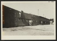 [recto] Exterior view of Granada motor pool garage after storm of June 25, 1945, showing one-half of roof lifted off. ;  Photographer: McGovern, Melvin P. ;  Amache, Colorado.