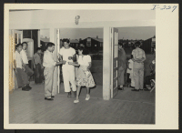 [recto] Closing of the Jerome Center, Denson, Arkansas. Jerome young folks are seen entering the recently completed recreation hall and movie theatre to view the final showing of the last feature attraction, Humphrey Bogart in Sahara. ;  Photographer: Iwasaki,