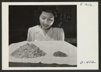 [recto] Mary Sakai demonstrating the loss in volume of vegetables after dehydration. ;  Photographer: Stewart, Francis ;  Rivers, Arizona.