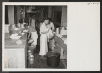 [recto] Volunteer K.P.'s help out in the dining car kitchen. A group of young transferees are shown washing dishes after the noon meal. ;  Photographer: Mace, Charles E. ; , .