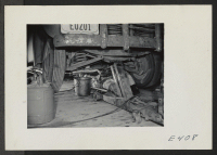 [recto] A young nisei mechanic under a project car in a temporary shop. ;  Photographer: Parker, Tom ;  Denson, Arkansas.