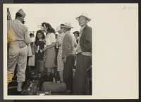 [recto] Closing of the Jerome Center, Denson, Arkansas. Military Police assist evacuees entering the chair cars on the June 13th trip to the Gila River Center. ;  Photographer: Mace, Charles E. ;  Denson, Arkansas.