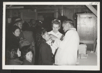 [recto] New arrivals receiving medical checkup. ;  Photographer: Aoyama, Bud ;  Heart Mountain, Wyoming.