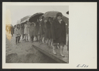 [recto] Grade school children leaving the school, at the Jerome Relocation Center. During the rainy season, in the heart of the Arkansas lowlands, the Jerome Center, whose residents are former Californians of Japanese ancestry, was one vast quagmire. ;  Photogr