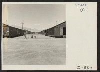 [recto] Manzanar, Calif.--Looking north between blocks of barracks on a hot summer day. This center for evacuees of Japanese ancestry has been opened about three months. ;  Photographer: Lange, Dorothea ;  Manzanar, California.