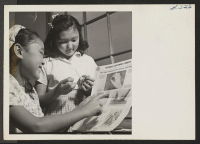 [recto] Joan Ritchie, left, and Janet Sakamoto, students at the Heart Mountain High School, learn to make patches in school sewing class. ;  Photographer: Iwasaki, Hikaru ;  Heart Mountain, Wyoming.