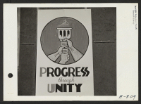 [recto] New Year's Fair. This symbol and the words Progress Thru Unity were adopted by the fair committee as the official insignia of the New Year's Fair, which was held in Camp No. 2. ;  Photographer: Stewart, Francis ;  Poston, Arizona.
