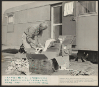 [recto] Unpacking belongings in this temporary trailer home at the Winona Housing Project in Burbank, California, where returned evacuees find temporary living quarters until they are able to secure homes in or around Los Angeles, Calif. ;  Photographer: Parker