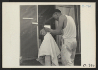 [recto] Manzanar, Calif.--Little evacuee of Japanese ancestry gets a haircut. ;  Photographer: Lange, Dorothea ;  Manzanar, California.
