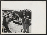 [recto] A scene at Heart Mountain during the unloading of trip 24 from Tule Lake when hand luggage was sorted and loaded on trucks to be conveyed to the barracks. ;  Photographer: Mace, Charles E. ; , .