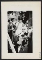 [recto] A stretcher and several mothers and babies are shown boarding the Pullman on one of the segregation trains from Jerome to Tule Lake. Picture was taken from the rear of the first aid car. ;  Photographer: Lynn, Charles R. ;  Dermott, Arkansas.