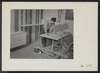 [recto] Constructing and decorating model apartment to show possibilities using scrap materials. George Nakashima, architect. Former occupation: architect. Former residence: Seattle, Washington. ;  Photographer: Stewart, Francis ;  Hunt, Idaho.