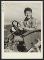 [recto] Kitao Tanabe, a young relocatee from the Rohwer Center, enjoys running a cultivator on the farm of Miss Rose Tanaka, where he is employed with a number of others from Rohwer, Granada and Heart Mountain. ;  Photographer: Mace, Charles E. ;  Henderson,