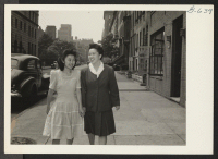 [recto] Takako Matsumoto (left) and Ritsuko Nakaji [Kanaji] (right) stroll along a street in New York City where they have resettled. ...