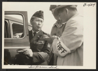 [recto] Dressed in uniform marking service in the first World War, this veteran enters Santa Anita Park assembly center for persons of Japanese ancestry evacuated from the West Coast. ;  Photographer: Albers, Clem ;  Arcadia, California.
