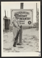 [recto] Private Noyama of Headquarters Company, 442nd combat team, stands guard at the entrance to Field Headquarters. The combat team wears ...