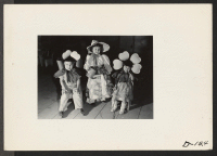 [recto] Three little nursery school children in costumes worn in the Labor Day parade. The little girl in the center recites Mary, Mary Quite Contrary. The two other children are her flowers. ;  Photographer: Stewart, Francis ;  Newell, California.
