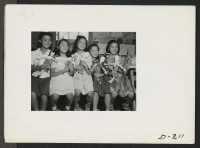 [recto] Five little school girls proudly hold the dolls they made in school. These dolls were on display in the exhibit of school handicraft which was held on Labor Day. ;  Photographer: Stewart, Francis ;  Newell, California.