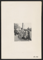 [recto] Hayward, Calif.--With baggage piled on sidewalk, evacuees of Japanese ancestry await evacuation bus. Evacuees will be housed in War Relocation Authority centers for the duration. ;  Photographer: Lange, Dorothea ;  Hayward, California.