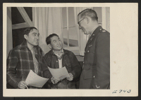 [recto] Captain William S. Fairchild discusses the Army with a couple of young Nisei volunteers about to fill out their enlistment ...