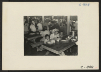 [recto] Manzanar, Calif.--Mealtime in one of the mess halls at this War Relocation Authority center for evacuees of Japanese ancestry. ;  Photographer: Lange, Dorothea ;  Manzanar, California.