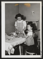 [recto] Mrs. Fred Ouye, or Mary, as she is know to her host of friends in Kansas City, prepares the evening ...