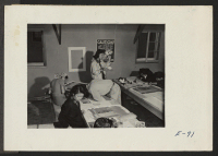 [recto] The poster crew at this relocation center, turning out fire and safety post announcements for public gatherings, dances and some general instructions. ;  Photographer: Parker, Tom ;  Heart Mountain, Wyoming.