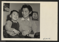 [recto] Nisei mother, Alice Hosokawa, wife of the editor of the Sentinel, Heart Mountain Relocation Center newspaper, and her two year old son, Mike. ;  Photographer: Parker, Tom ;  Heart Mountain, Wyoming.