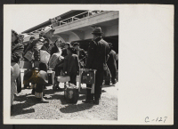 [recto] San Bruno, Calif.--Family of Japanese ancestry arrives at Assembly Center at Tanforan Race Track. Evacuees will be transferred later to War Relocation Authority centers where they will be housed for the duration. ;  Photographer: Lange, Dorothea ;  Sa