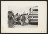 [recto] The bus has just arrived and these farm families of Japanese ancestry are being kept intact enroute to the Assembly Center. ;  Photographer: Lange, Dorothea ;  Centerville, California.