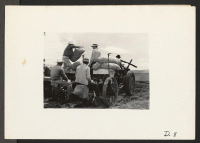 [recto] Tule Lake, Newell, Calif.--Loading a potato planter with sacks of seed potatoes while the evacuee crew relaxes between rounds of planting. ;  Photographer: Stewart, Francis ;  Newell, California.