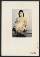 [recto] This picture of mother and child was taken for evacuee use. This picture is interesting from a documentary angle, however, for it shows the proud mother holding the doll-like featured child. ;  Photographer: Stewart, Francis ;  Newell, California.