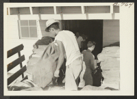 [recto] Back of post office at Poston--a branch office of the Phoenix post office--showing sacks of mail ready to be taken into the office and sorted for delivery. Four tons of Sears Roebuck catalogues arrived at this office during the week of August 24. ;  Pho