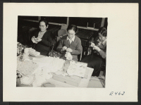 [recto] Three members of an adult crocheting class. The instructor (center) teaches students to crochet everything from doilies to lapel trinkets and flower pot covers. ;  Photographer: Parker, Tom ;  Amache, Colorado.