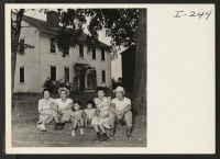 [recto] The Kusudo brothers and their families in front of their typical New England house at Red Bird Farm, Wrentham, Mass. ...