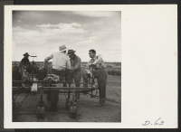 [recto] Tule Lake, Newell, Calif.-- Foster Goss, associate information specialist, and Edwin Bates, Chief of the Information Division, interview evacuee-farmers on the farm at this War Relocation Authority center. ;  Photographer: Stewart, Francis ;  Newell,
