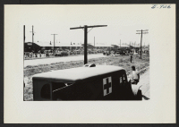 [recto] General view of operations at departure time of segregation train from Jerome to Tule Lake. This picture was taken from the train. One truck-load of segregees can be seen finding their hand luggage in right center. ;  Photographer: Lynn, Charles R. ;