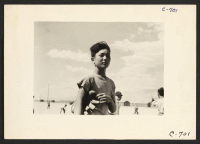 [recto] Manzanar, Calif.--Young evacuee baseball player, member of one of the eighty teams which has been organized at this War Relocation Authority center for evacuees of Japanese ancestry. ;  Photographer: Lange, Dorothea ;  Manzanar, California.
