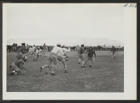 [recto] Scene during a game between the All Stars and the Jack Rabbits, two of the favorite teams of Heart Mountain football fans. ;  Photographer: Iwasaki, Hikaru ;  Heart Mountain, Wyoming.