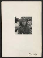 [recto] Hayward, Calif.--A young member of an evacuee family awaiting evacuation bus. Evacuees of Japanese ancestry will be housed in War Relocation Authority centers for the duration. ;  Photographer: Lange, Dorothea ;  Hayward, California.