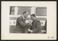 [recto] Hayward, Calif.--The Reverend John Carlos Derfelt (left), Baptist Minister, ties identification tag in coat lapel of the Reverend Sui Hiro ...