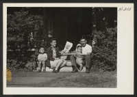 [recto] Mr. and Mrs. George Nobori, formerly of the Jerome Relocation Center, now living in Cleveland where Nobori is employed as a machinist. They are seen with their two children on the porch of a house they have rented in a new residential section of the city.