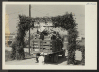 [recto] Closing of the Jerome Center, Denson, Arkansas. One of the hundreds of truck loads of household furnishings belonging to the new residents of Rohwer is seen passing through the Welcome Arch at that center. ;  Photographer: Mace, Charles E. ;  Denson,