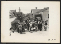 [recto] Members of farm families await evacuation bus. Farmers and other evacuees will be given opportunities to follow their callings at War Relocation Authority centers where they will spend the duration. ;  Photographer: Lange, Dorothea ;  Centerville, Cal