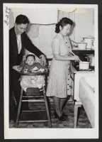 [recto] Mr. and Mrs. Kaname Fred Ota and their nine month old baby girl, Madeline, in the kitchen of their New ...