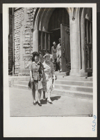 [recto] Evacuees coming out of the Central Methodist church in Detroit after attending services on Sunday, June 20, 1943. In the ...