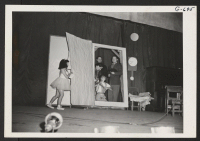 [recto] Opening scene of the Talent Show sponsored by Tri-State High School student body June 9 at Tule Lake Center to help finance the annual. Shown is Reiko Kumasaki, Nisei tot who had a toe-dancing contract with a film studio pre-evacuation. --Faculty departme