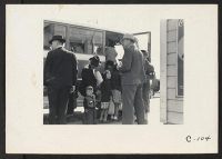[recto] Byron, Calif.--The bus which will take this farm family of Japanese ancestry to the Assembly Center is almost ready to leave. Note identification tag on small boy. ;  Photographer: Lange, Dorothea ;  Byron, California.