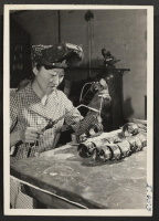 [recto] Miss Jeri Tanaka, Nisei, is employed by the Modern Lighting and Manufacturing Company in Des Moines as a welder. She ...