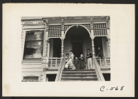 [recto] Sacramento, Calif.--Children of Japanese ancestry play on the front porch of their home, two days before evacuation. ;  Photographer: Lange, Dorothea ;  Sacramento, California.